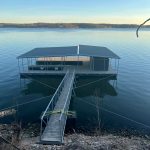Covered multi slip boat dock with a long gangway extending from the shoreline on Grand Lake in Oklahoma