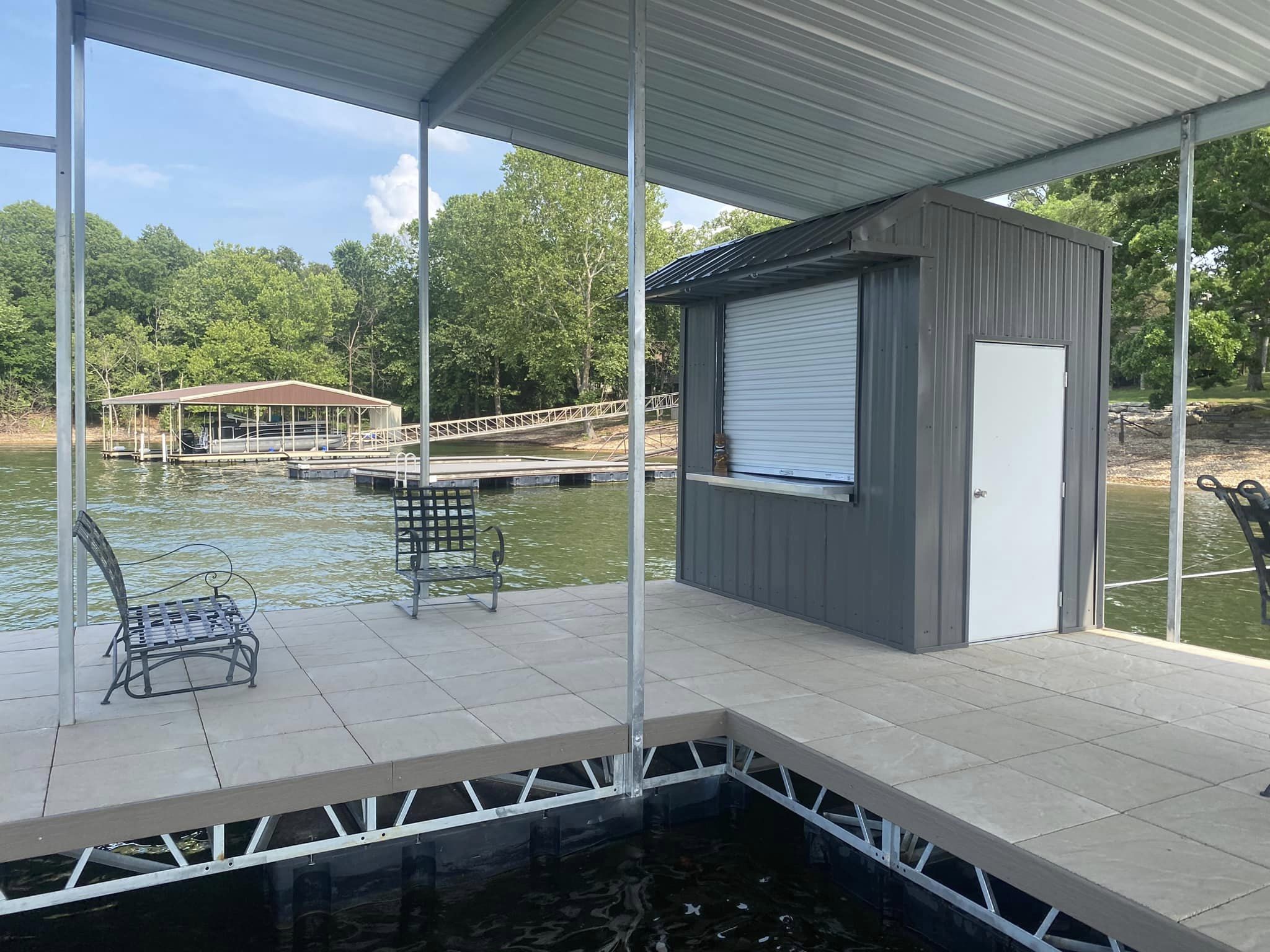 Covered boat dock with dock house, tiled deck, and seating area on Grand Lake in Oklahoma