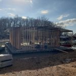 Partially built custom dock structure on Grand Lake Oklahoma during construction with framing, roof panels, and boat lift equipment nearby