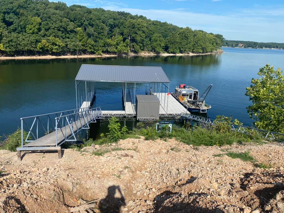 Covered boat dock with metal frame, ramp, and lift on Grand Lake Oklahoma shoreline