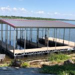 Covered multi slip boat dock on Grand Lake in Oklahoma with metal roof, open slips, and lakefront water access