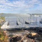 Partially built multi slip dock structure on the shoreline at Grand Lake Oklahoma with aluminum framing and open lake views