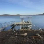 Custom lakefront dock and boat lift area on Grand Lake Oklahoma with metal gangways and open water views