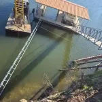Covered boat dock and lift installation on Grand Lake in Grand Lake Oklahoma, featuring a metal gangway and lakefront access
